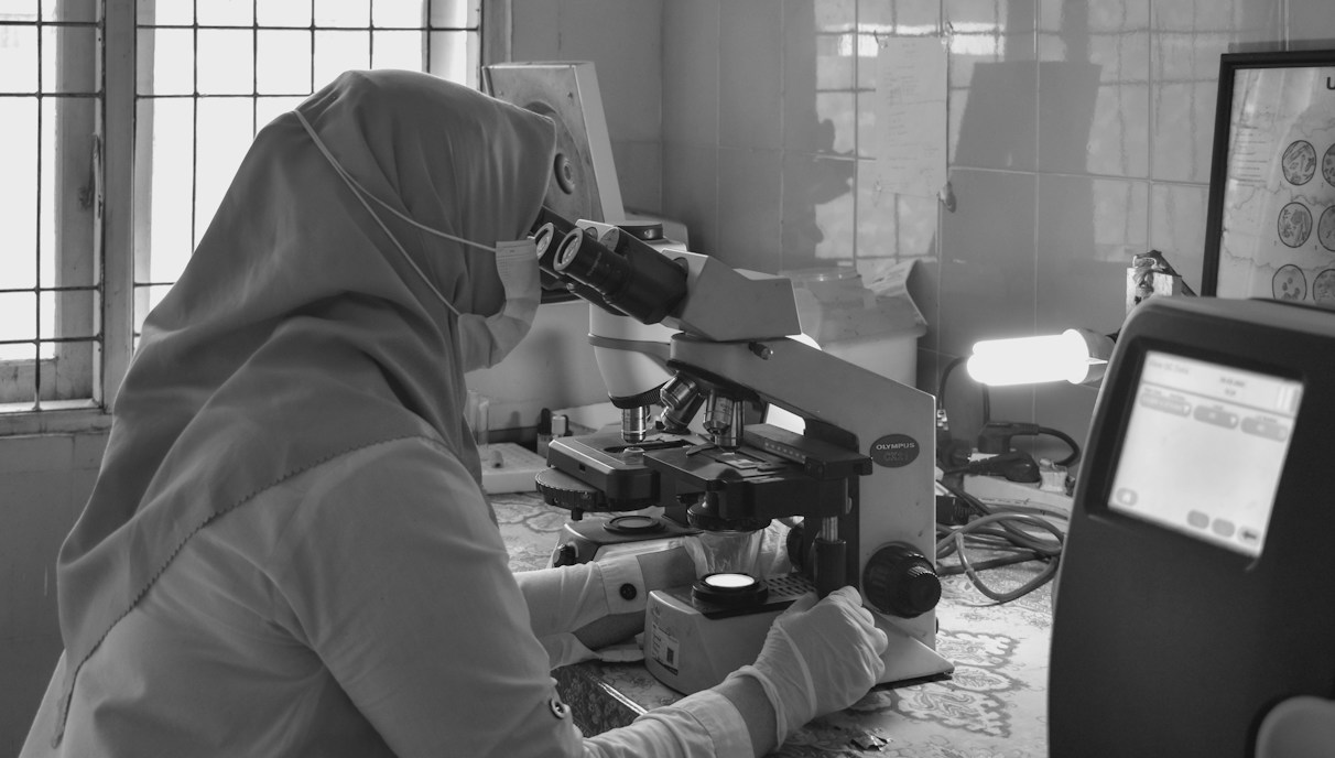 Lab technician analyzing exosome samples under a microscope with high-tech instruments.
