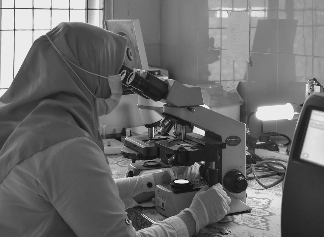 Lab technician analyzing exosome samples under a microscope with high-tech instruments.